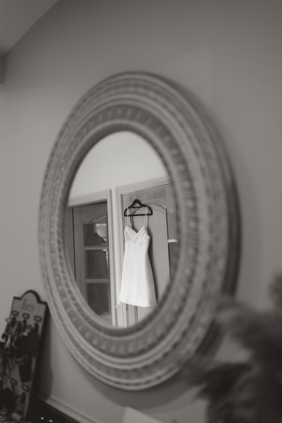 night time evening wedding dress hanging in the mirror during bridal prep